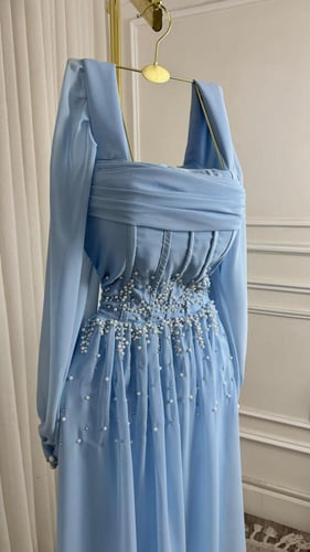 فستان سماوي ناعم بتطريز لؤلؤ يدوي وأكمام طويلة