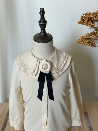 قميص باللون البيج مع فيونكة