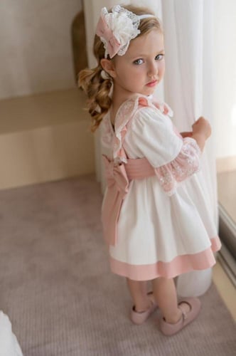 فستان أبيض بحزام وردي وياقة دانتيل