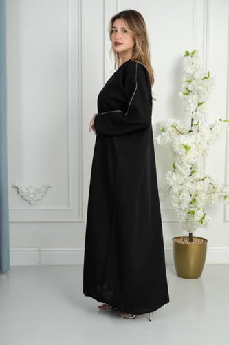 عباية سوداء مزينة بخط أبيض أنيق