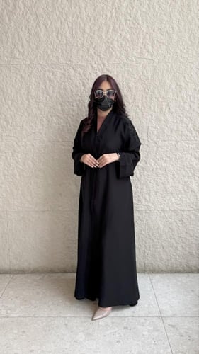 عباية سوداء مطرزة بوردة على الأكمام