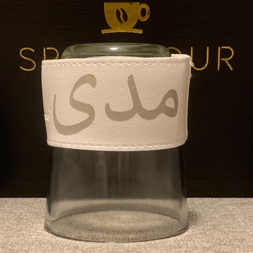 كوب زجاجي شفاف مع جلدة باللون ( الأبيض )