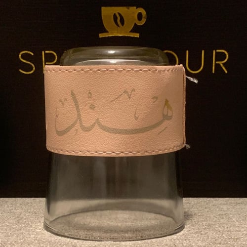 كوب زجاجي شفاف مع جلدة باللون ( الوردي - الزهري )