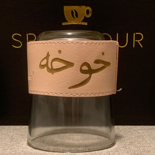 كوب زجاجي شفاف مع جلدة باللون ( الوردي - الزهري )