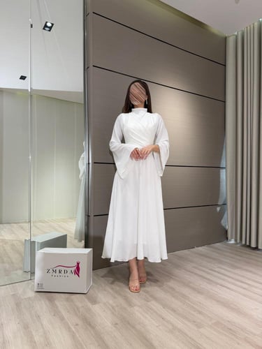 فستان ابيض طويل بياقة مرتفعة وتصميم لف