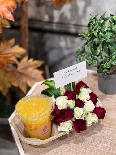 كوب عصير من بتنسيق ورد ميني روز أبيض وأحمر