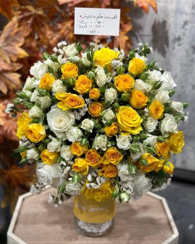 فازة ورد أصفر وأبيض مع كتابة عبارة او إسم