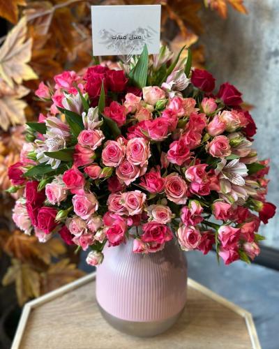 فازة ورد وردية منسقة بتشكيلة ورود جميلة