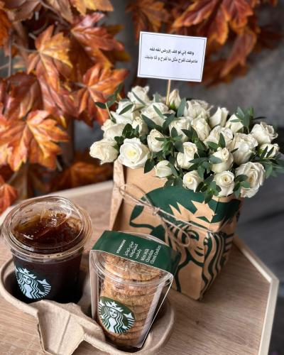 باقة ورد داخل كيس مع كوكيز و كوب قهوة