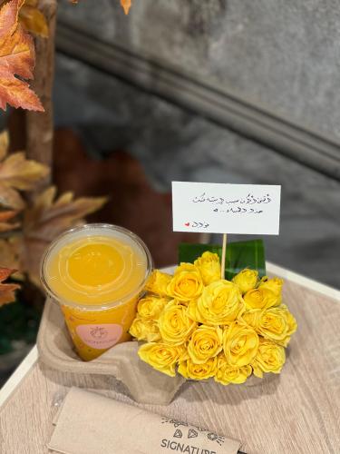 كوب عصير من بتنسيق ورد ميني روز أصفر