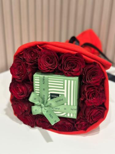 شوكولاتة باتشي الفاخرة منسقة وسط ورد جوري احمر مغل...