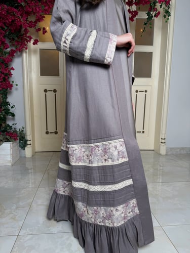 عباية باللون الرمادي متداخلة بقماش مورد