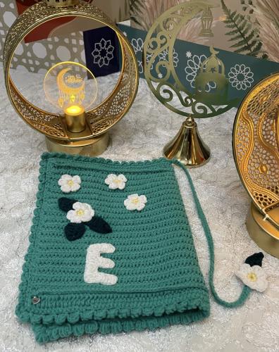 Green Quran cover with floral patterns and letter