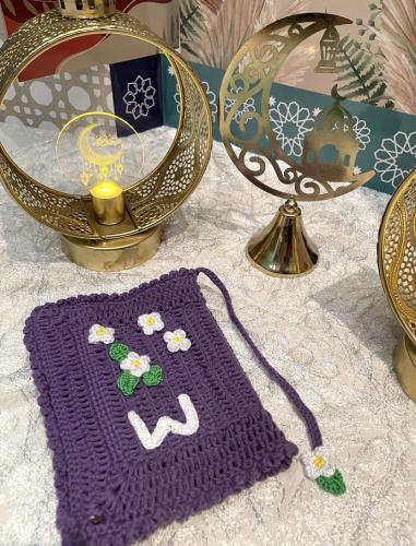 Purple Quran cover with roses and a letter