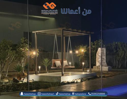 برجولة حديد مودرن مع أرجوحة خشبية وإضاءة خارجية