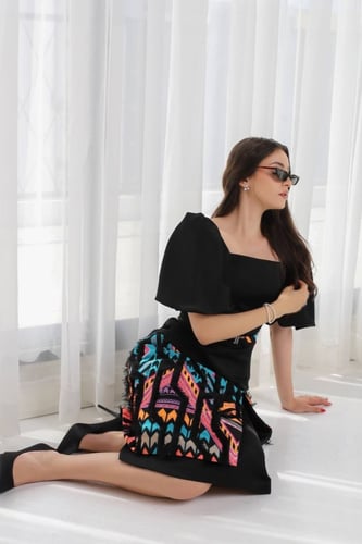 فستان اسود ممزوج بألوان مميزة واكمام منفوخة