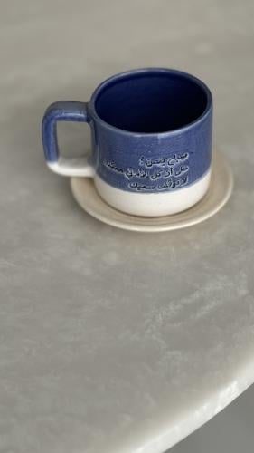 كوب مع طبق بعبارة ( صباح ينص على أن كل الأماني ممك...