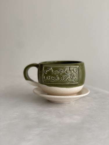 كوب مع طبق بعبارة (وَما نَيلُ المَطالِبِ بِالتَمَن...