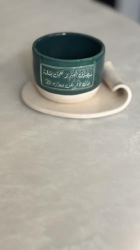 كوب مع طبق بعبارة (سيصْدُقُ الغَيمُ لا تعجَل بشارت...