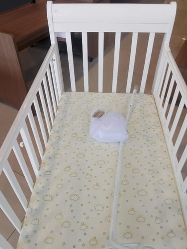 سرير اطفال يتميز بالبساطة بلون أبيض