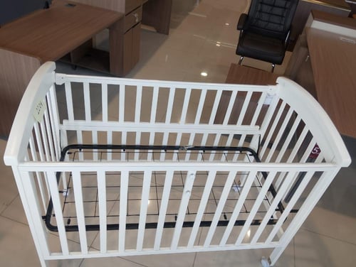 سرير أطفال بتصميم خشبي يتميز بالاناقة بلون أبيض