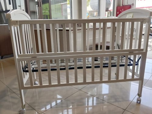 سرير أطفال بتصميم خشبي يتميز بالاناقة بلون أبيض