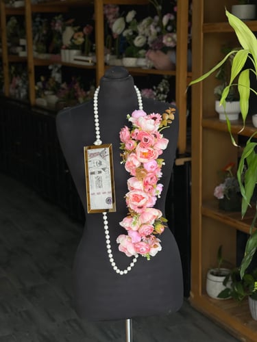 A graduation necklace decorated with pearls and fl...