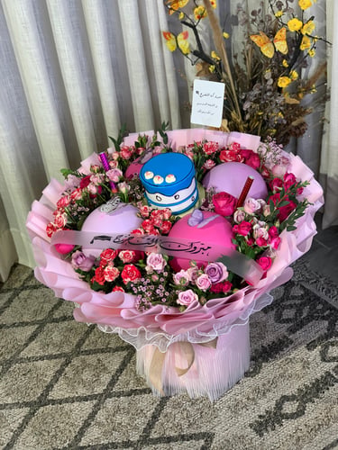 A bouquet of flowers with cake and balloon