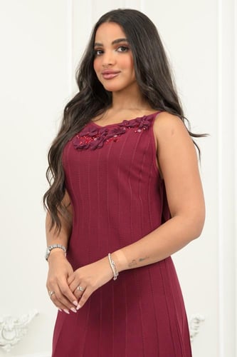 فستان يتميز بلون عنابي فاخر بتفاصيل ناعمة من الورو...