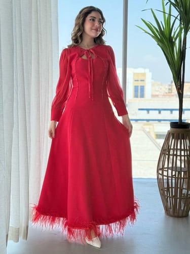 فستان بتفاصيل ناعمة وربطة عنق جذابة وريش يزيّن الأ...