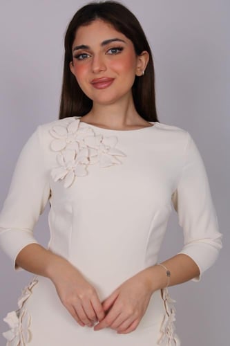 فستان أنيق بلون كريمي ناعم، بتصميم راقٍ يبرز الأنو...