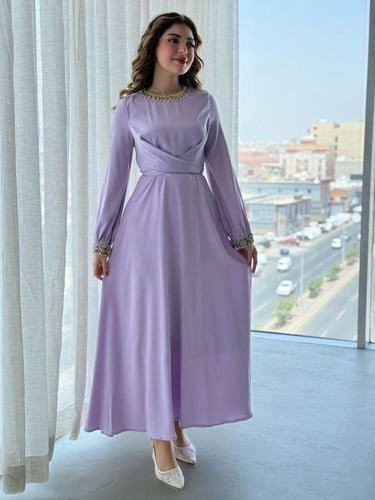 فستان بتفاصيل براقة على الياقة والأكمام وتصميم يلف...