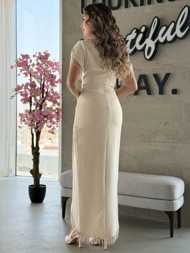 فستان بفتحة أمامية ملتفّة وأطراف مزينة بالخرز اللا...