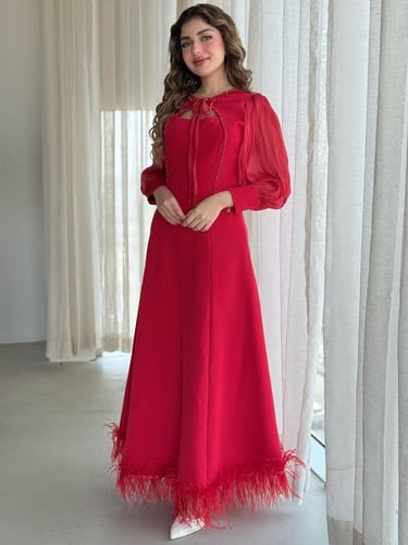 فستان بتفاصيل ناعمة وربطة عنق جذابة وريش يزيّن الأ...