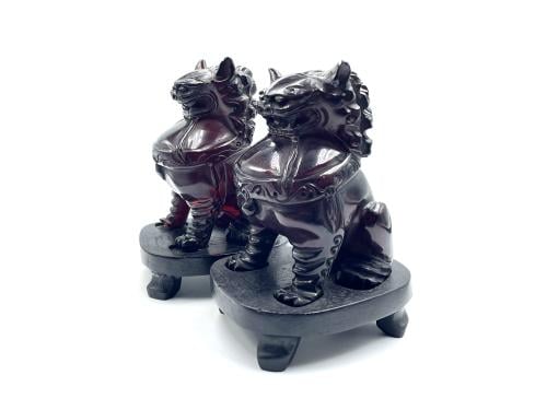 Two Faturan lion statues with ancient cast wooden bases