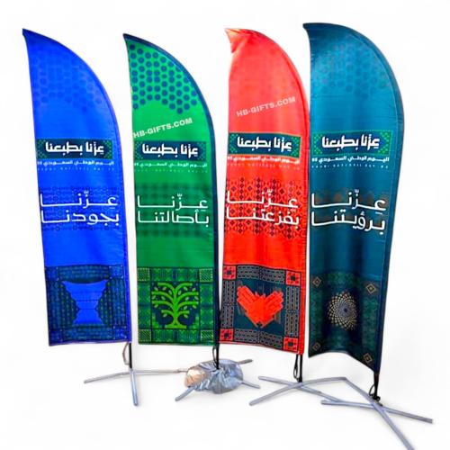 اعلام شراع مصممة مع شعار عزنا بطبعنا باربع الوان م...