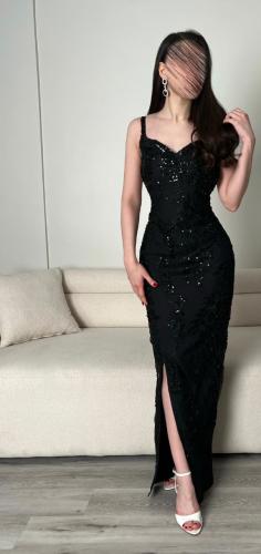 فستان سهرة أسود فاخر يتميز بتطريز دقيق وحبيبات براقة وتصميم أنثوي ضيق مع فتحة جانبية