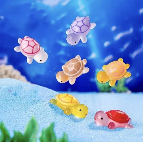 سلاحف بلاستيكية صغيرة وملونة، ذات أصداف شفافة وعنا...