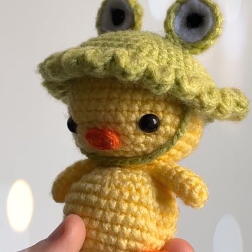 دمية بطة بقبعة ضفدع كروشيه