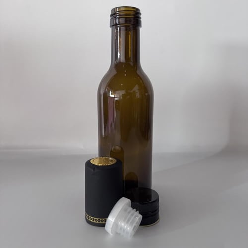 قارورة زجاجية غامق اللون يستخدم زيت الزيتون و العص...