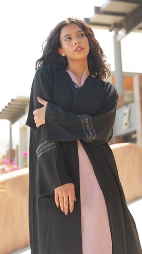 عباية سوداء مع فستان وردي