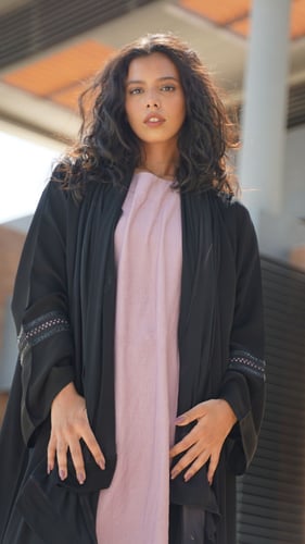 عباية سوداء مع فستان وردي