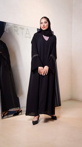 عباية سوداء مع فستان وردي