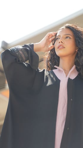 عباية سوداء مع فستان وردي