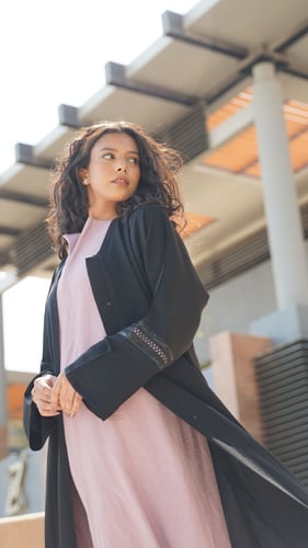 عباية سوداء مع فستان وردي