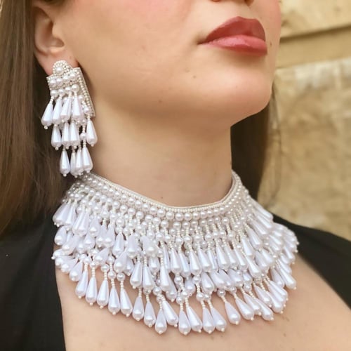 طقم عبارة عن عقد واقراط اذن من الخرز باللون الابيض