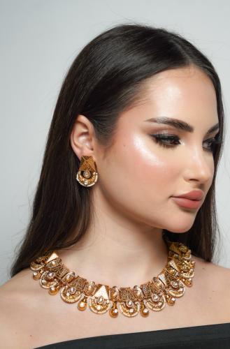 طقم هندي مطلي بتصميم تقليدي عبارة عن عقد واقراط اذ...