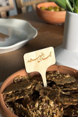 تغريسة خشبية منحوتة بعبارة "عيد اضحى سعيد"