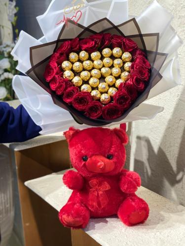 A bouquet with chocolate, floral, and teddy bear