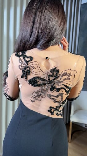 فستان أسود بتفاصيل شفافة وتطريز فاخر